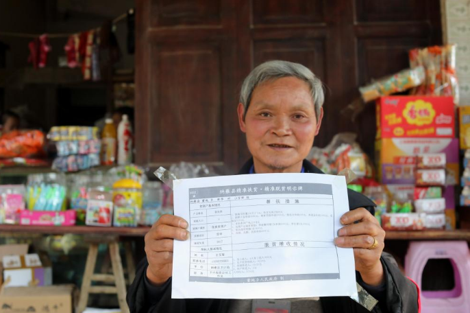 贵州省毕节市纳雍县董地乡新华村村民彭先荣在家门前展示自己家的"