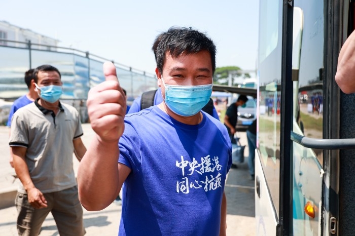 4月8日，建设者们身穿文化衫，带着灿烂的笑容离开驻地。摄影：贾凯.jpg