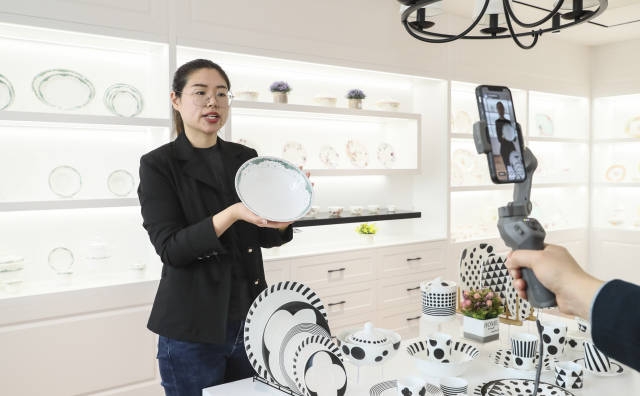 4月15日，江苏省淮安市洪泽区，淮安一家陶瓷企业的工作人员在展厅直播介绍产品。新华社发