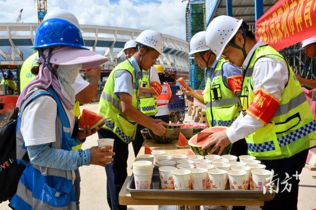 施工工地，工人们在领取西瓜、绿豆汤等清凉食品。南方日报记者朱洪波通讯员韦荣贵摄