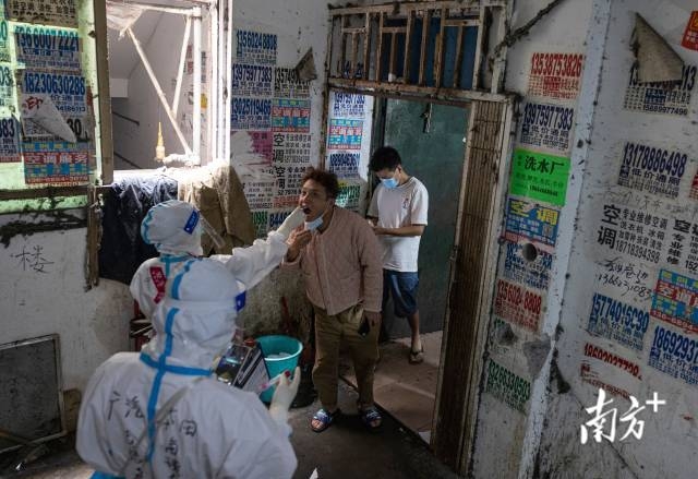 第十二网格片区内的外来务工人员接受核酸采样。