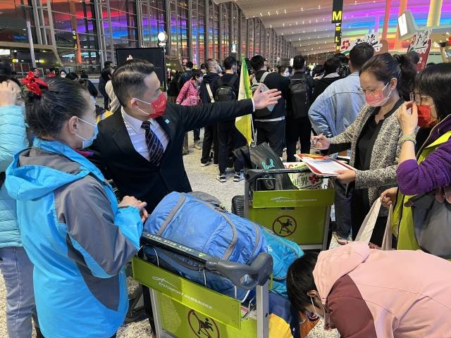 首批出境游团队领队之一吴国亮向游客作行前指引。